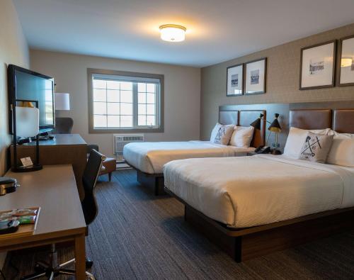 a hotel room with two beds and a desk at Best Western Gold Rush Inn in Whitehorse