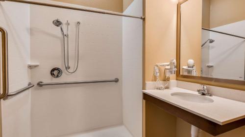y baño con ducha y lavamanos. en Best Western St. Louis Airport North Hotel & Suites en Hazelwood