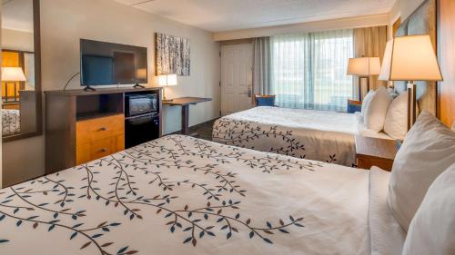 um quarto de hotel com duas camas e uma televisão de ecrã plano em Best Western Plus of Birch Run/Frankenmuth em Birch Run