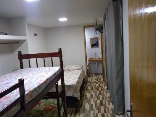 um pequeno quarto com 2 camas e um lavatório em Kitnet contêiner climatizada em Ubatuba