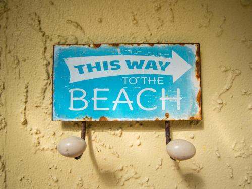 a sign on a wall that says this way to the beach at Beach Tata - Golden Bay Bach Tata Beach in Tarakohe