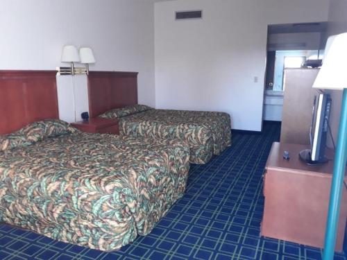 a hotel room with two beds and a flat screen tv at Sunset Inn and Suites in Seward