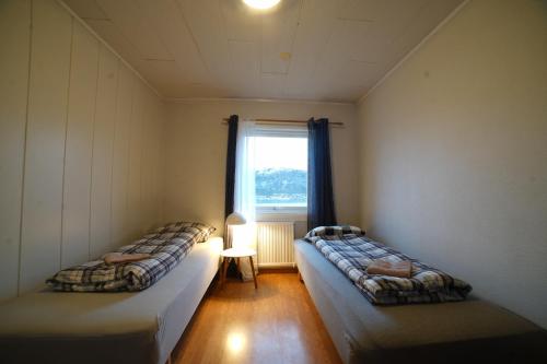 two beds in a room with a window at Mary Rooms in Tromsø
