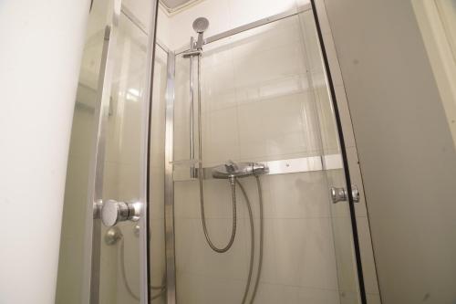 a shower in a bathroom with a glass door at Hage Rooms in Tromsø
