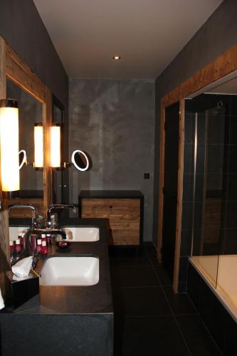 a bathroom with two sinks and a shower at M de Megève in Megève