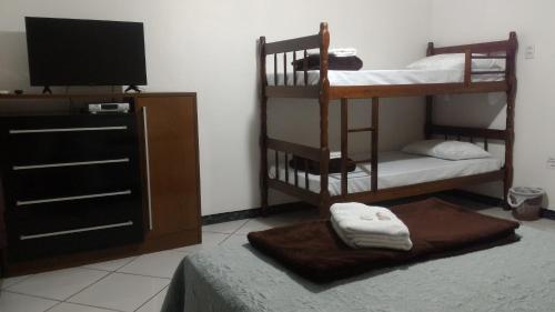 a room with two bunk beds and a flat screen tv at Pousada Progresso in Gravata