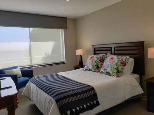 a bedroom with a bed and a large window at Departamento Reñaca in Viña del Mar