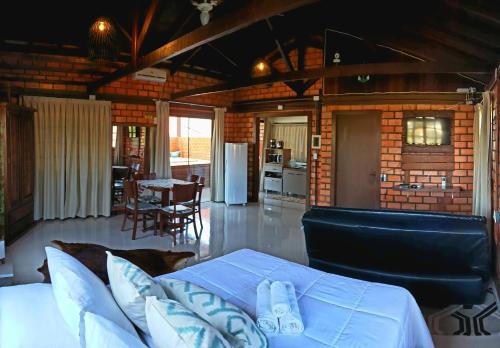 a living room with a bed and a dining room at Pousada Doce Mar in Guarda do Embaú