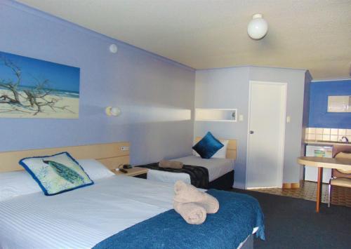 a hotel room with two beds and a stuffed animal on the bed at Rockhampton Court Motor Inn in Rockhampton