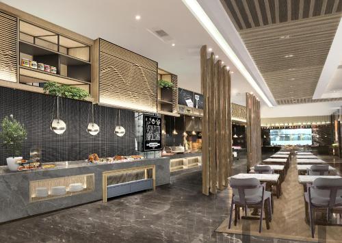 a restaurant with a buffet line with tables and chairs at Holiday Inn Foshan Nanhai Central, an IHG Hotel in Foshan