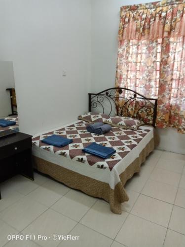 a bed sitting in a room with a window at YIE HOMESTAY muslim friendly in Kampong Bukit Dukong