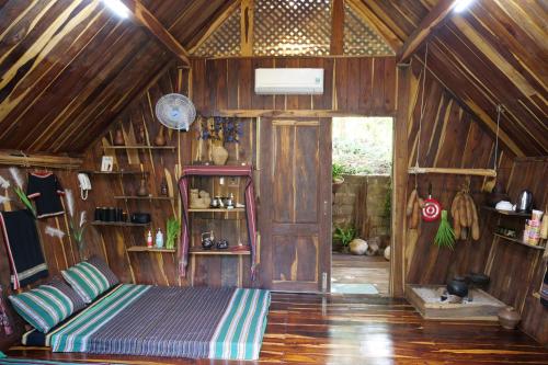 1 dormitorio con 1 cama en una habitación de madera en Khu Du Lịch Sinh Thái AkoEa, en Buon Ma Thuot