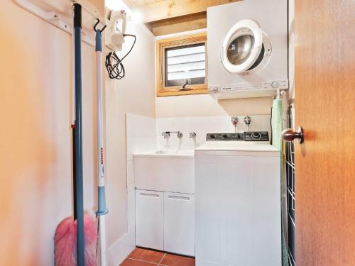 a small kitchen with a sink and a washing machine at Banjo Apartments in Thredbo