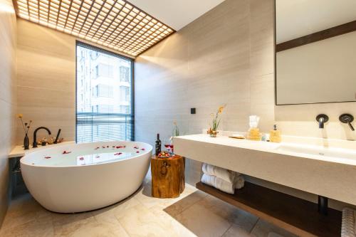 a bathroom with a large tub and a large window at SSAW Boutique Hotel Hangzhou Liangyun in Hangzhou