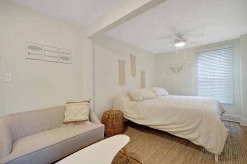 Un dormitorio blanco con una cama y un sofá. en The Melrose, en Ocean Grove