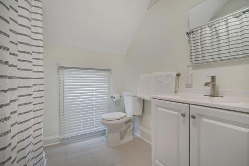 a white bathroom with a toilet and a sink at The Melrose in Ocean Grove