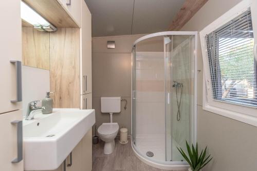 a bathroom with a shower and a sink and a toilet at Mobile home Pecten exclusive 2 in Pakoštane