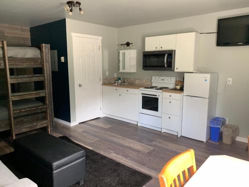a kitchen with white cabinets and a stove top oven at Peaks Lodge in Revelstoke