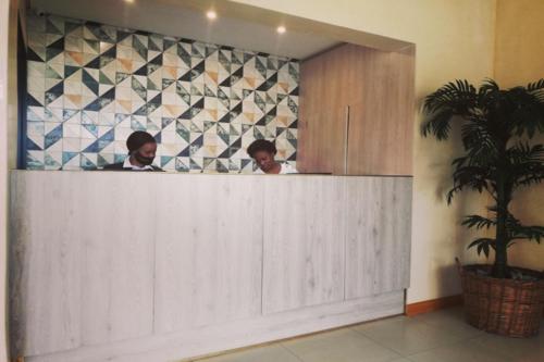 two men are standing in a bathroom mirror at Regal Inn North Beach in Durban
