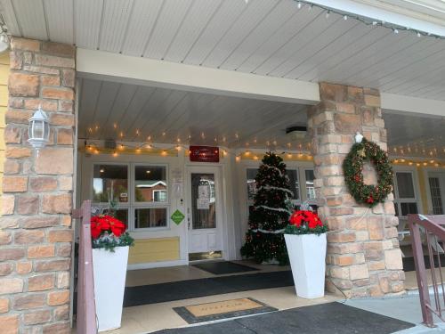 a front porch with christmas wreaths and christmas trees at Hotel and Suites Les Laurentides in Saint-Sauveur-des-Monts