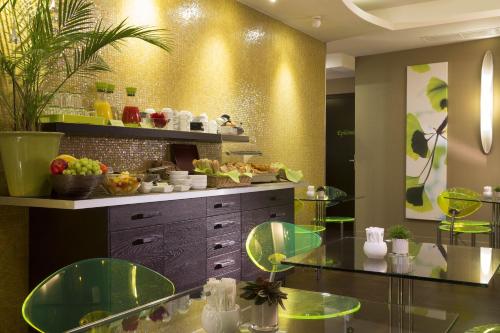 een keuken met groene werkbladen en glazen tafels bij Hôtel Le Fabe in Parijs