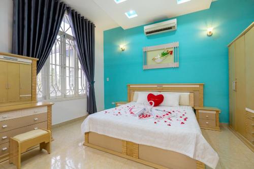 Un dormitorio con una cama con flores. en Victory Villa - Sân Vườn - Hồ Bơi - Karaoke - Gần Biển Bãi Sau en Vung Tau