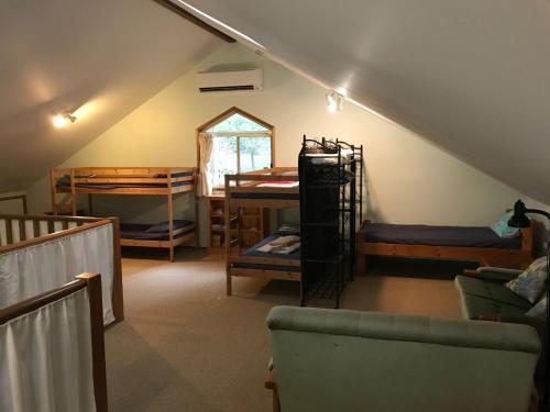 a attic room with bunk beds and a couch at Araluen in Smiths Lake