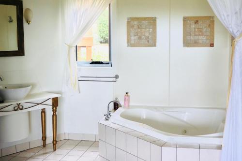 Baño blanco con bañera y lavamanos en Casa Vista, en Bangalow