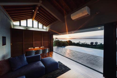 a living room with a couch and a view of the ocean at relax kouri villa Rekrrr in Nakijin
