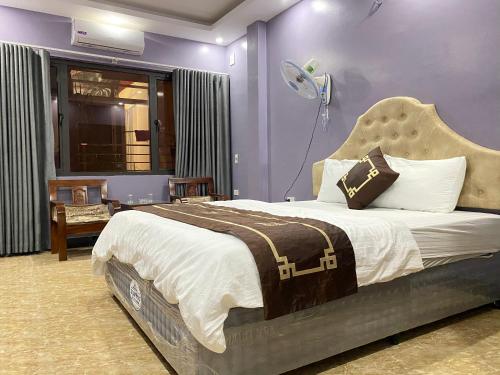 1 dormitorio con 1 cama grande y paredes moradas en New Sun Hotel en Hanoi