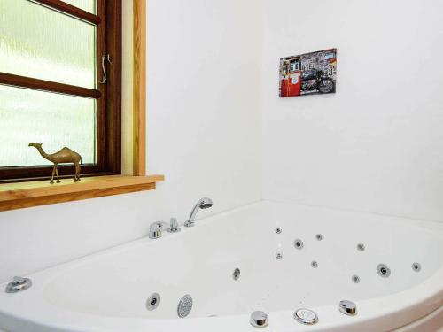 a bath tub in a bathroom with a window at Peaceful Holiday Home in Jutland with Sauna in Ebeltoft
