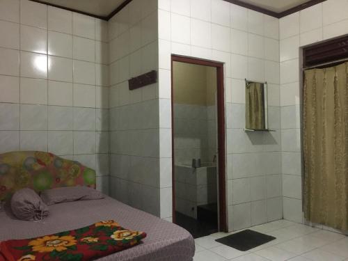a bedroom with a shower and a bed in it at Hotel SiCantik in Kaliurang