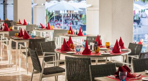 a restaurant with tables with red napkins on them at Mauricia Beachcomber Resort & Spa in Grand-Baie
