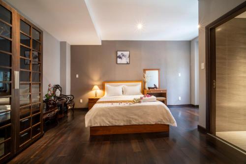 una camera con un grande letto e pavimenti in legno di Sen Spa Service Apartment ad Ho Chi Minh