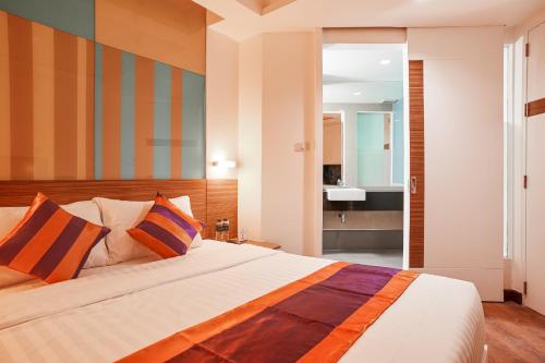 a bedroom with a large bed and a bathroom at Studio Asoke in Bangkok