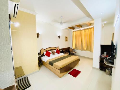 ein Schlafzimmer mit einem Bett und einem TV in der Unterkunft Hotel The Galaxy in Jabalpur