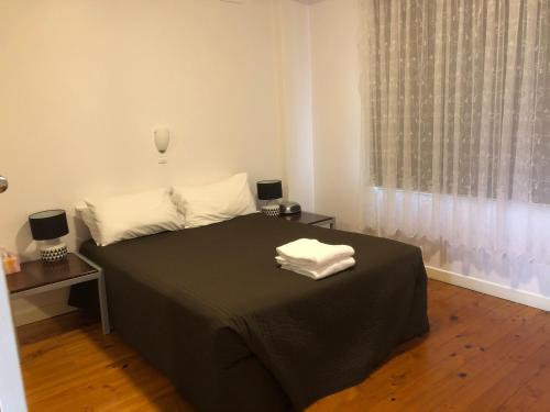 Glenelg Holiday Apartments-Ellis في أديلايد: غرفة نوم عليها سرير وفوط