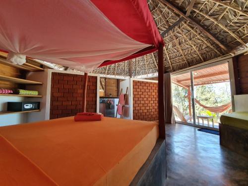een slaapkamer met een oranje bed in een huis bij Ocean Lodge Kite & Windsurf in Diego Suarez