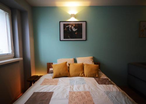 a bedroom with a bed with a picture on the wall at Apartmán v prírode s vlastnou saunou in Martin