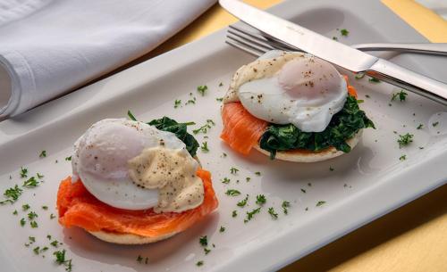 a white plate with two eggs on top of salmon at Atea Lodge in Coromandel Town