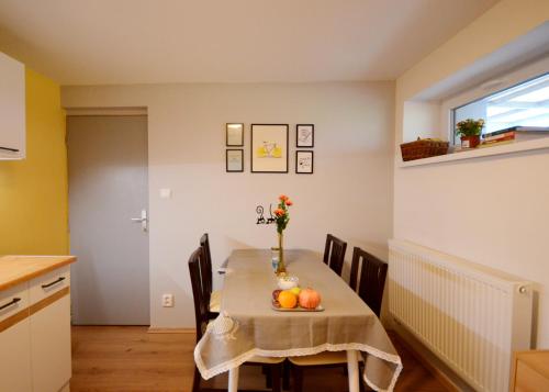 a dining room table with a vase of flowers on it at Apartmán v prírode s vlastnou saunou in Martin