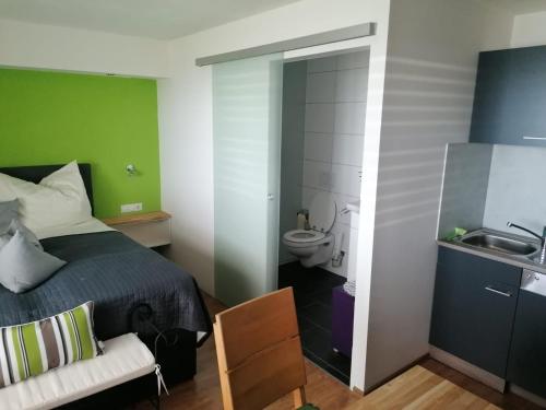 1 dormitorio con cama, aseo y lavamanos en Hausblick Matt, Lochau, en Lochau