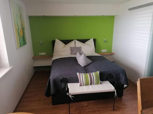 a bedroom with a bed with a green wall at Hausblick Matt, Lochau in Lochau