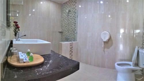 y baño con lavabo y aseo. en Hotel Pelangi Malang, Kayutangan Heritage, en Malang