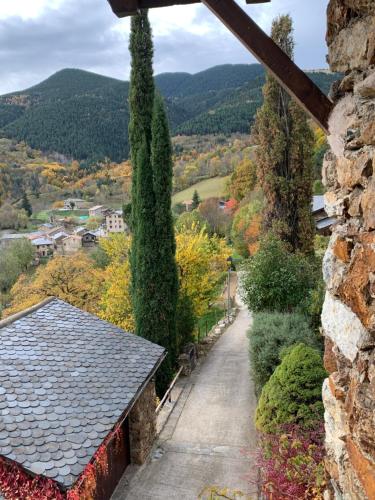 a view from a stone wall of a pathway with a tree at Casa Rural Pirineu Nevà in Nevà