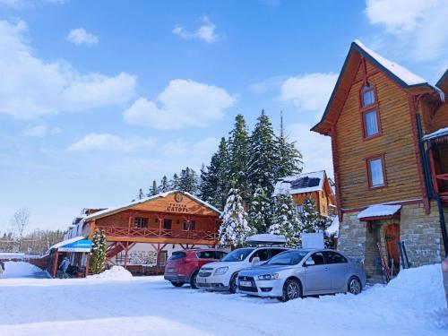 a group of cars parked in the snow in front of a building at Satori in Migovo