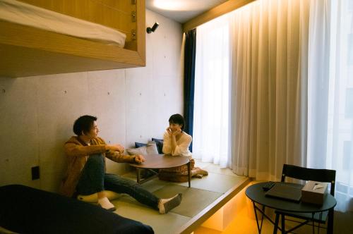 a man and a child sitting at a table in a room at Sakura Cross Hotel Shinjuku East Annex in Tokyo
