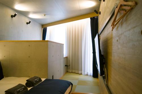 a small room with a bed and a window at Sakura Cross Hotel Shinjuku East Annex in Tokyo