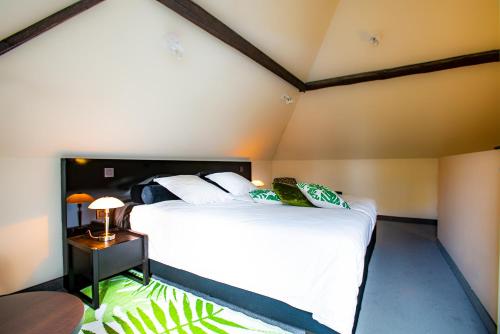 a bedroom with two beds with white sheets and a table at Villa Tilia in Retie
