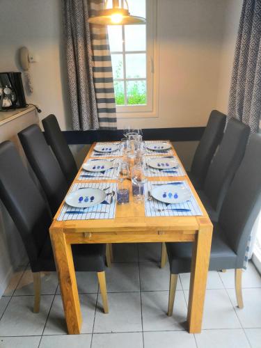 une table en bois entourée de chaises noires dans l'établissement Blue Ocean Cocoon, à Fort-Mahon-Plage